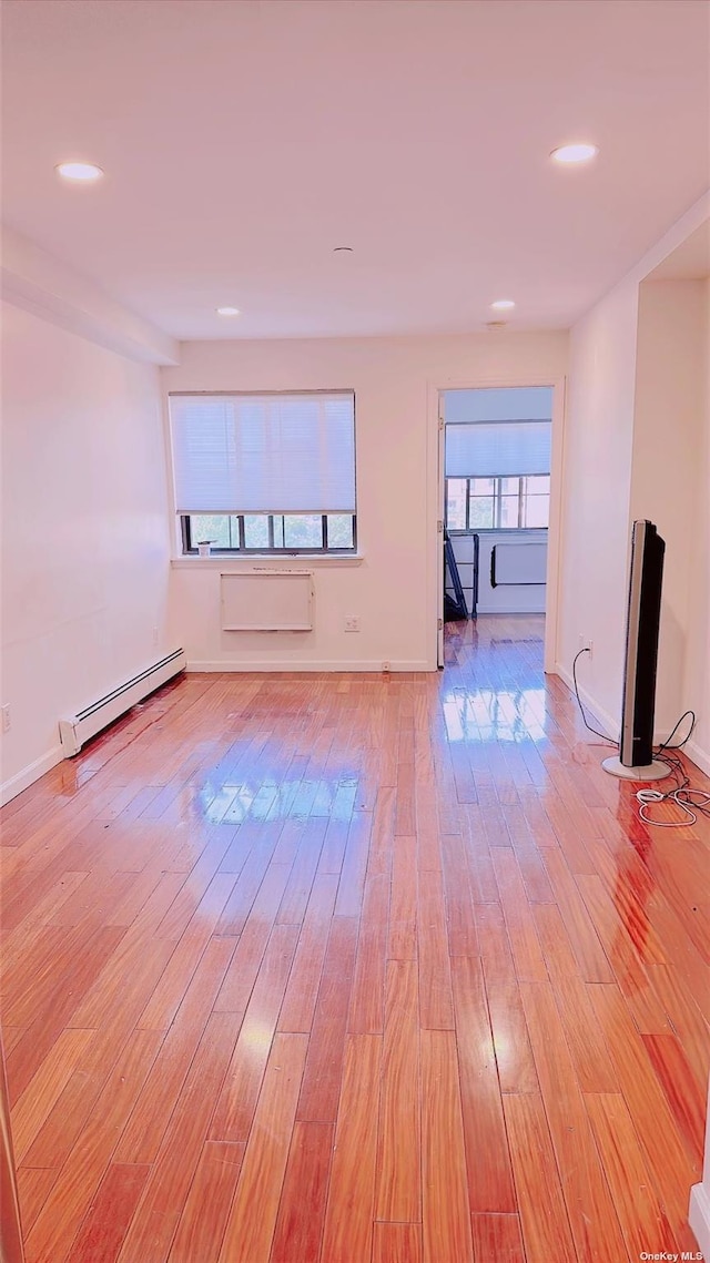 144-85 Roosevelt Ave Unit 5E, Flushing, NY 11354 - empty room featuring baseboard heating, light wood-style floors, recessed lighting, and a wall mounted AC