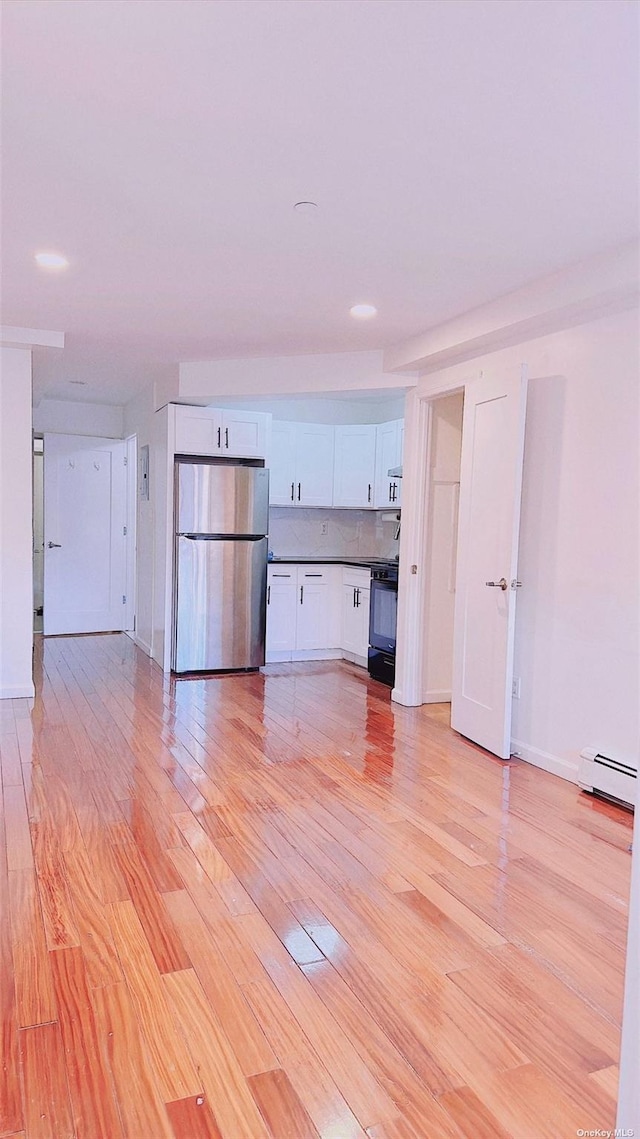 144-85 Roosevelt Ave Unit 5E, Flushing, NY 11354 - unfurnished living room featuring light wood-style flooring and baseboard heating