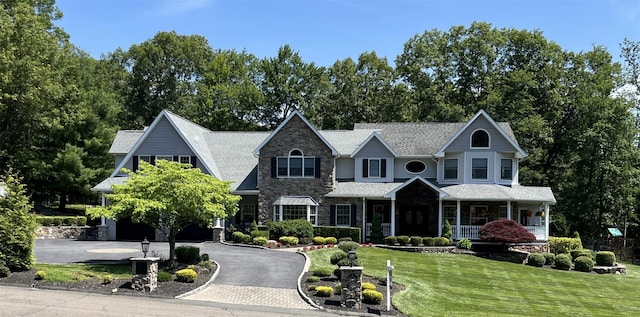 5 Odell Dr, Stony Point, NY 10980 - view of front of house with stone siding, curved driveway, a front yard, covered porch, and roof with shingles