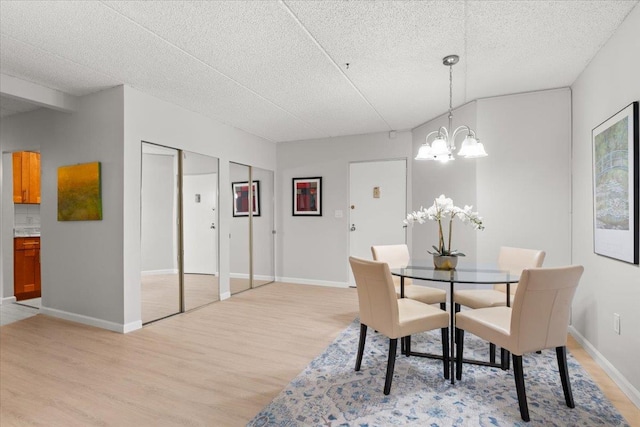 66 Crisfield St Unit 2B, Yonkers, NY 10710 - dining space featuring light wood finished floors, a chandelier, and a textured ceiling
