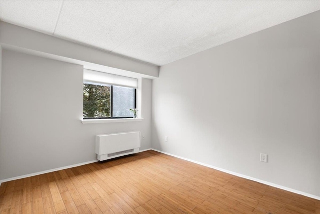 66 Crisfield St Unit 2B, Yonkers, NY 10710 - unfurnished room featuring radiator, hardwood / wood-style floors, and a textured ceiling