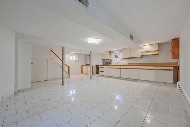 42 S Montague St, Valley Stream, NY 11580 - below grade area with healthy amount of natural light, light tile patterned floors, and a baseboard radiator