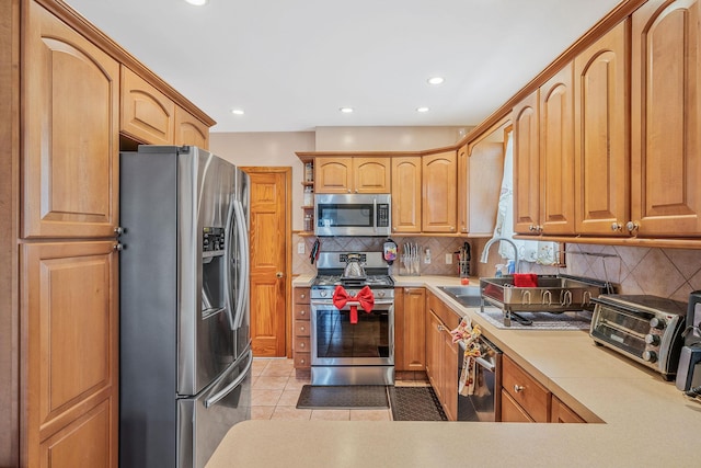 42 S Montague St, Valley Stream, NY 11580 - kitchen with appliances with stainless steel finishes, tasteful backsplash, light countertops, light tile patterned flooring, and recessed lighting
