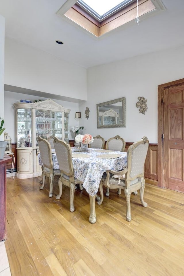1464 Potter Blvd, Bay Shore, NY 11706 - dining area with a skylight, wood finished floors, and a wainscoted wall