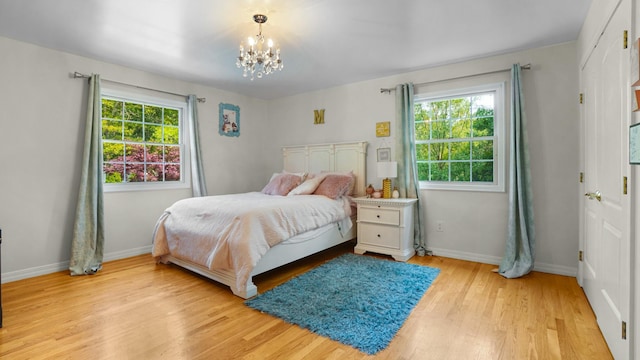 59 Lidge Dr, Farmingville, NY 11738 - bedroom with a chandelier and light wood-style floors
