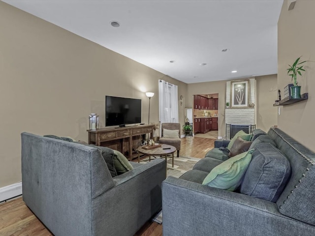 2677 Heath Ave, Bronx, NY 10463 - living room featuring light wood-style flooring, a brick fireplace, and recessed lighting