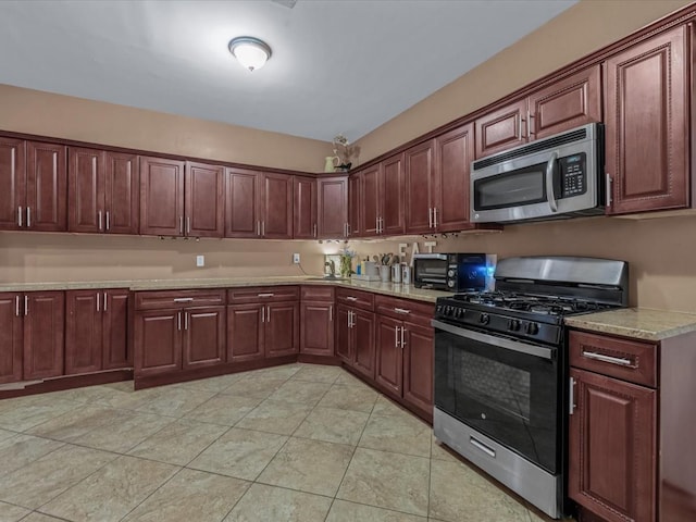 2677 Heath Ave, Bronx, NY 10463 - kitchen featuring stainless steel microwave, black range with gas cooktop, light tile patterned floors, and light stone counters