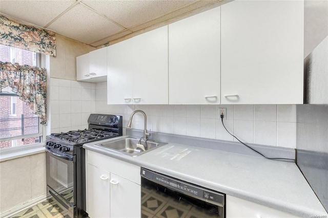 67-66 108th St Unit A58, Forest Hills, NY 11375 - kitchen featuring black appliances, light countertops, a paneled ceiling, healthy amount of natural light, and white cabinetry
