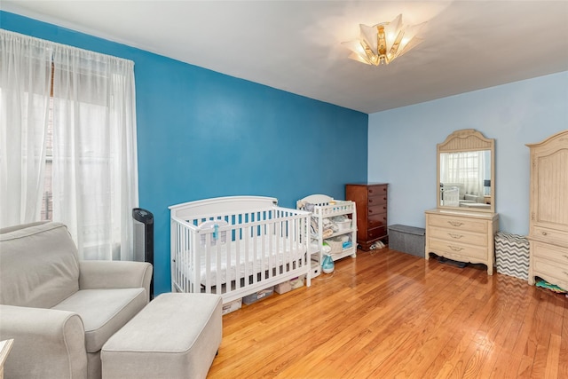 67-66 108th St Unit A58, Forest Hills, NY 11375 - bedroom featuring wood-type flooring and a crib