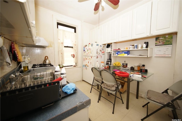 40-45 99th St, Corona, NY 11368 - kitchen with freestanding refrigerator, a ceiling fan, white cabinetry, backsplash, and light flooring