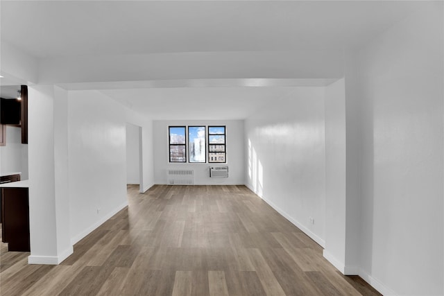 3184 Grand Unit 6D, Bronx, NY 10458 - spare room with radiator, light wood-type flooring, and a wall mounted air conditioner