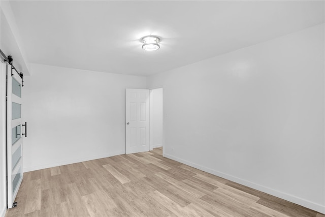3184 Grand Unit 6D, Bronx, NY 10458 - spare room with a barn door and light wood-style floors