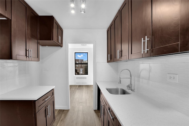 3184 Grand Unit 6D, Bronx, NY 10458 - kitchen featuring radiator heating unit, light countertops, decorative backsplash, dark brown cabinets, and light wood-type flooring