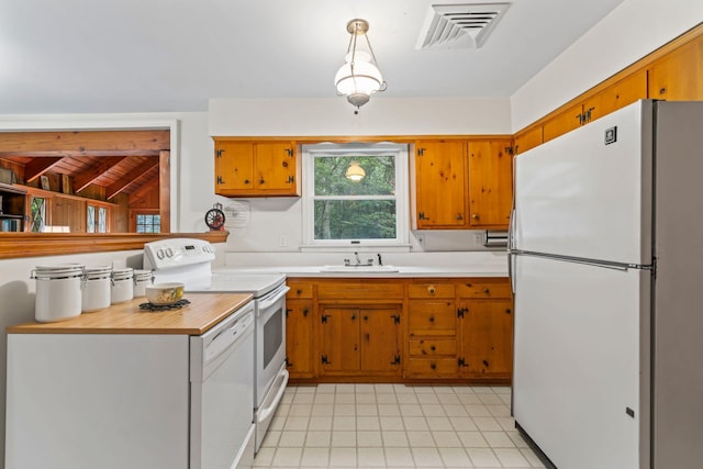 27 E Woods Dr, Cold Spring Harbor, NY 11724 - kitchen with white appliances, light countertops, brown cabinetry, light tile patterned floors, and decorative light fixtures