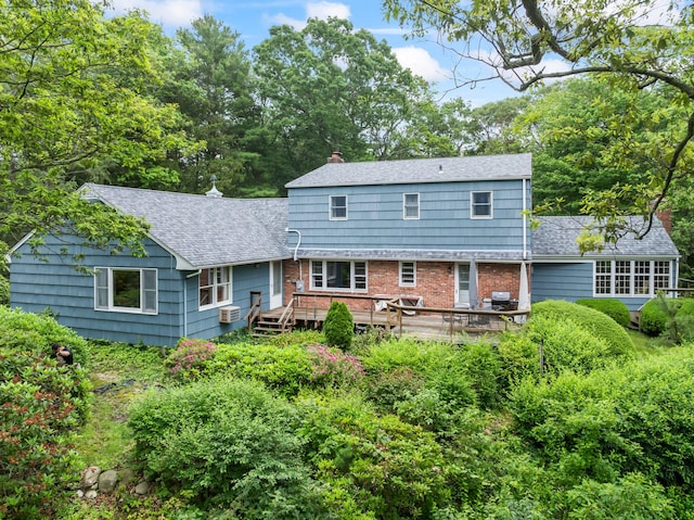 27 E Woods Dr, Cold Spring Harbor, NY 11724 - back of property with roof with shingles, a deck, brick siding, and a chimney