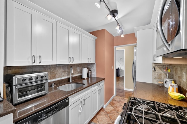505 Central Ave Unit 408, White Plains, NY 10606 - kitchen with stainless steel appliances, white cabinetry, dark stone countertops, decorative backsplash, and rail lighting