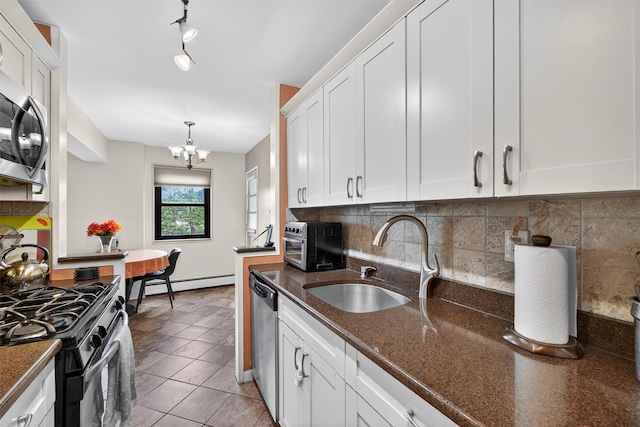 505 Central Ave Unit 408, White Plains, NY 10606 - kitchen with stainless steel appliances, a baseboard radiator, white cabinetry, a chandelier, and decorative backsplash