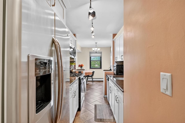 505 Central Ave Unit 408, White Plains, NY 10606 - kitchen featuring stainless steel appliances, dark countertops, a baseboard heating unit, white cabinets, and light tile patterned flooring