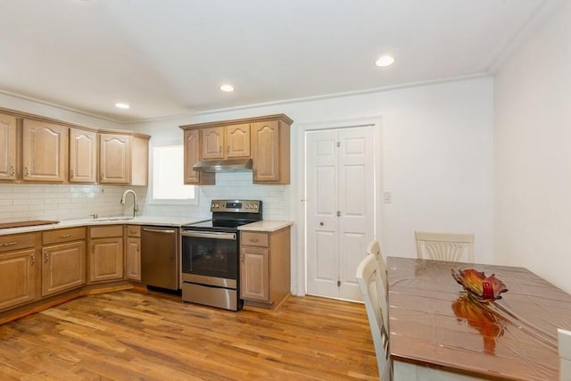 118 Pine Neck Ave, East Patchogue, NY 11772 - kitchen with stainless steel appliances, under cabinet range hood, decorative backsplash, light wood-type flooring, and light countertops