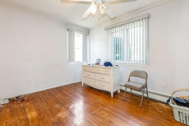 118 Pine Neck Ave, East Patchogue, NY 11772 - sitting room featuring a baseboard heating unit, wood finished floors, ceiling fan, and crown molding