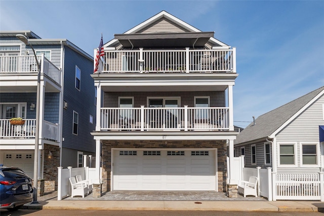 87 Arizona Ave, Long Beach, NY 11561 - view of front of property featuring a balcony, a garage, and stone siding