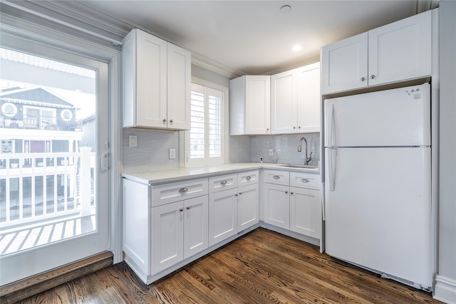 87 Arizona Ave, Long Beach, NY 11561 - kitchen with freestanding refrigerator, light countertops, dark wood-style floors, white cabinets, and ornamental molding