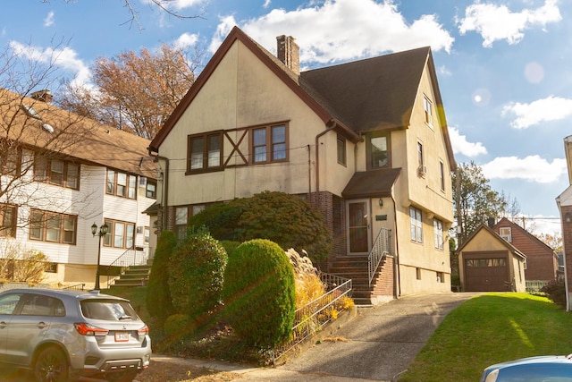 136 Sturges St, Staten Island, NY 10314 - view of front of home featuring a chimney, stucco siding, driveway, a detached garage, and stairs