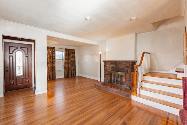 136 Sturges St, Staten Island, NY 10314 - unfurnished living room featuring wood finished floors, stairs, a brick fireplace, and ornamental molding