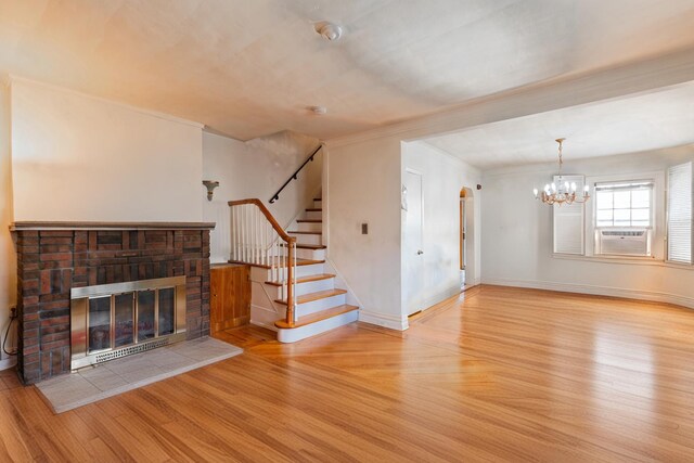 136 Sturges St, Staten Island, NY 10314 - unfurnished living room with wood finished floors, a chandelier, crown molding, stairs, and a brick fireplace
