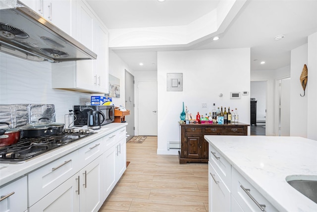 136-20 Booth Memorial Ave Unit 3H, Flushing, NY 11355 - kitchen with range hood, stainless steel microwave, recessed lighting, light wood-style flooring, and white cabinets