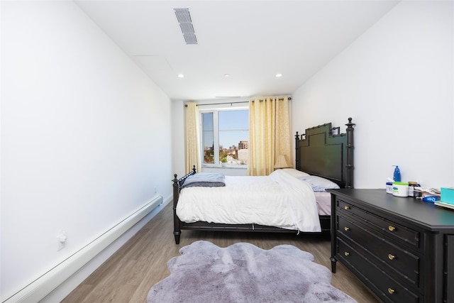 136-20 Booth Memorial Ave Unit 3H, Flushing, NY 11355 - bedroom with a baseboard heating unit, wood finished floors, and recessed lighting