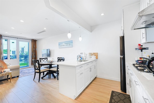 136-20 Booth Memorial Ave Unit 3H, Flushing, NY 11355 - kitchen featuring ventilation hood, a peninsula, light wood-type flooring, white cabinets, and hanging light fixtures