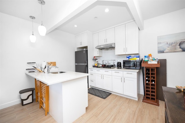 136-20 Booth Memorial Ave Unit 3H, Flushing, NY 11355 - kitchen with under cabinet range hood, appliances with stainless steel finishes, beam ceiling, light wood-style floors, and a peninsula