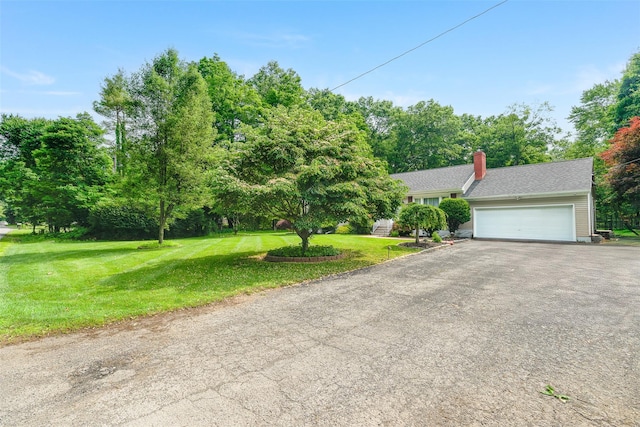63 Lake Walton Rd, Wappingers Falls, NY 12590 - view of front of house featuring a front lawn, asphalt driveway, an attached garage, a chimney, and view of wooded area