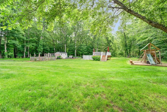 63 Lake Walton Rd, Wappingers Falls, NY 12590 - view of green lawn featuring a playground, an outbuilding, and a view of trees