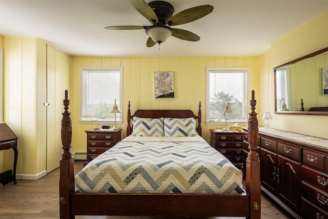 22 Creek Rd, Wading River, NY 11792 - bedroom featuring wood finished floors, multiple windows, a baseboard heating unit, and a ceiling fan