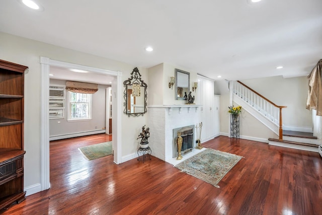 118 Grant Ave, Albertson, NY 11507 - unfurnished living room featuring a baseboard heating unit, wood finished floors, a fireplace, stairs, and recessed lighting