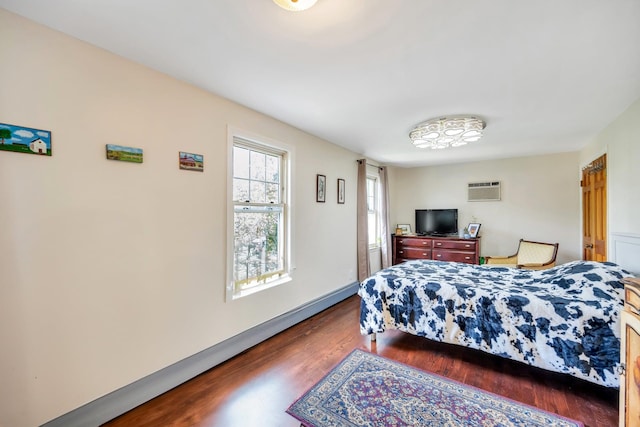 118 Grant Ave, Albertson, NY 11507 - bedroom with wood finished floors, a wall mounted AC, and baseboard heating