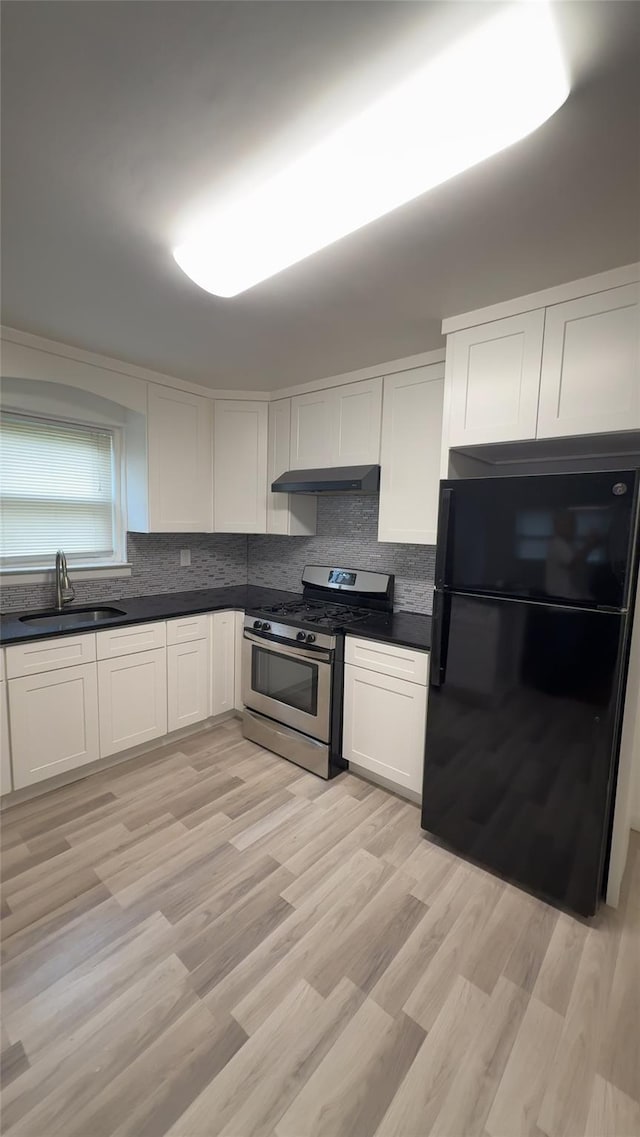 232-04 88th Ave, Queens Village, NY 11427 - kitchen featuring freestanding refrigerator, stainless steel range with gas cooktop, white cabinets, and decorative backsplash