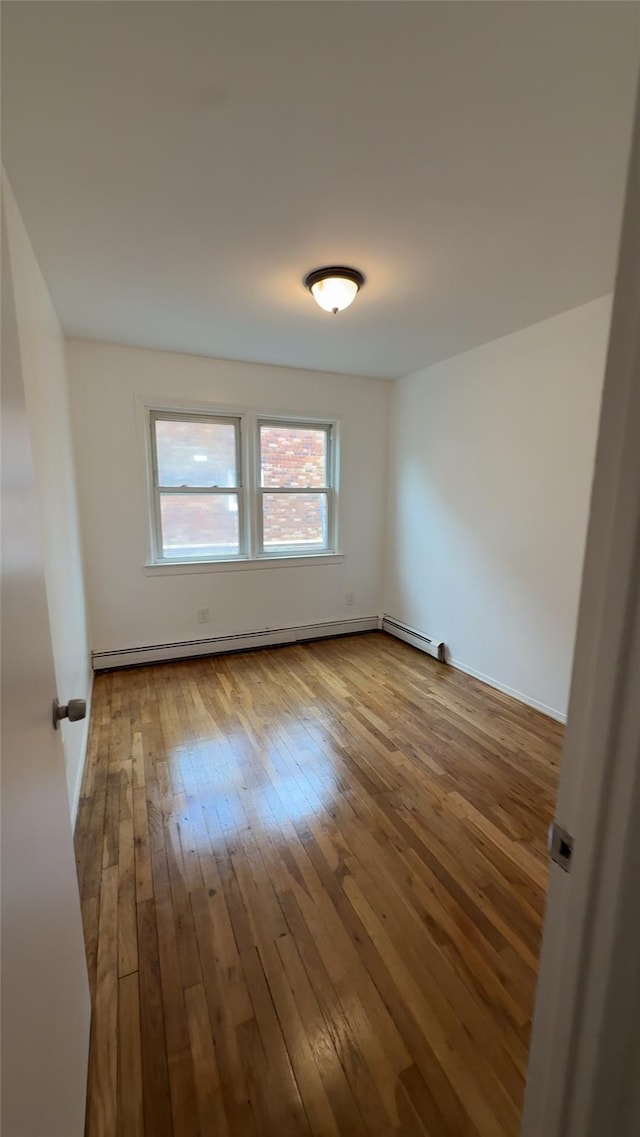 232-04 88th Ave, Queens Village, NY 11427 - spare room featuring wood-type flooring and a baseboard radiator