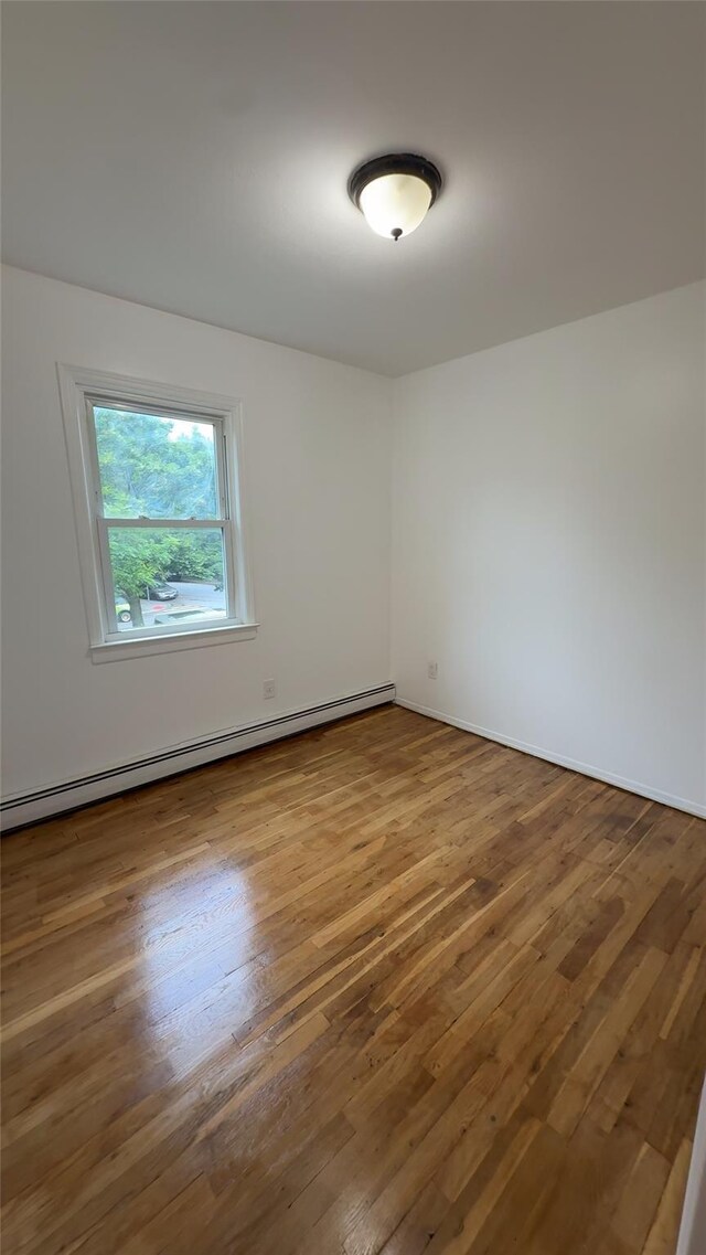 232-04 88th Ave, Queens Village, NY 11427 - unfurnished room with a baseboard radiator and wood finished floors