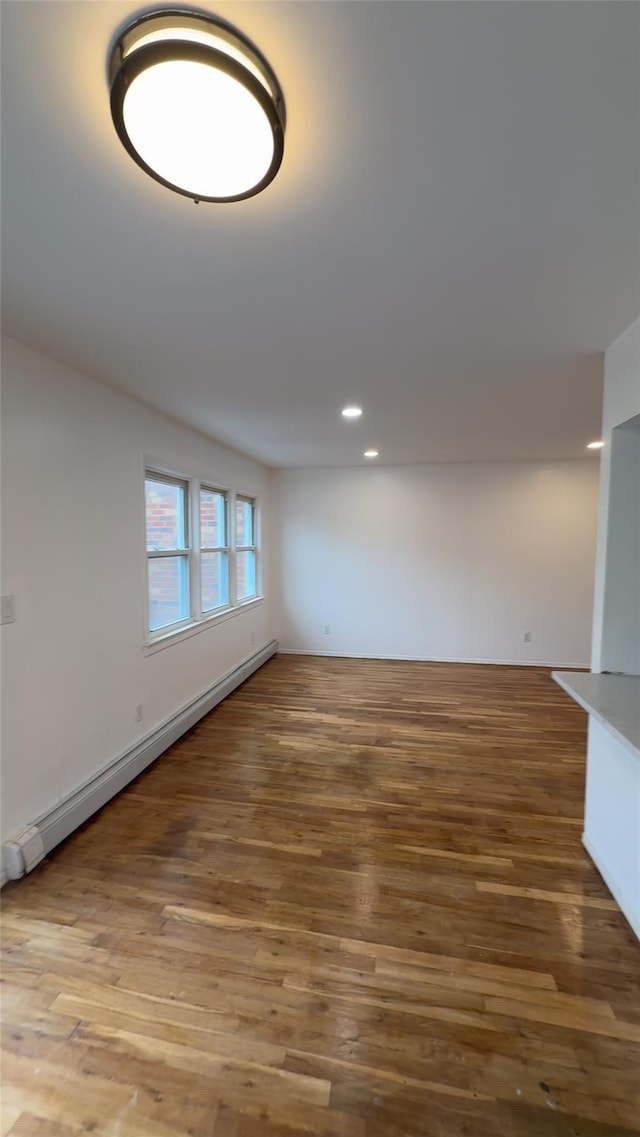 232-04 88th Ave, Queens Village, NY 11427 - spare room with baseboard heating, wood finished floors, and recessed lighting