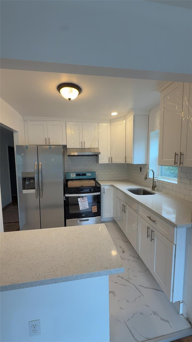 232-04 88th Ave, Queens Village, NY 11427 - kitchen featuring appliances with stainless steel finishes, under cabinet range hood, light marble finish flooring, and tasteful backsplash