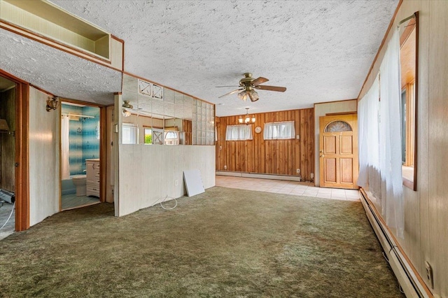 2354 7th St, East Meadow, NY 11554 - unfurnished living room featuring a baseboard radiator, ceiling fan, carpet flooring, wood walls, and a textured ceiling