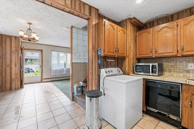 2354 7th St, East Meadow, NY 11554 - laundry area with washer / dryer, a textured ceiling, wood walls, light tile patterned floors, and a chandelier