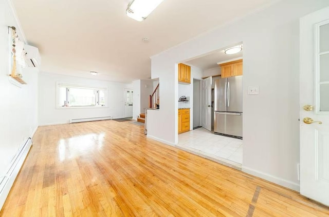 40-02 202nd St, Bayside, NY 11361 - unfurnished living room featuring baseboard heating, a baseboard heating unit, a wall mounted AC, and light wood-type flooring