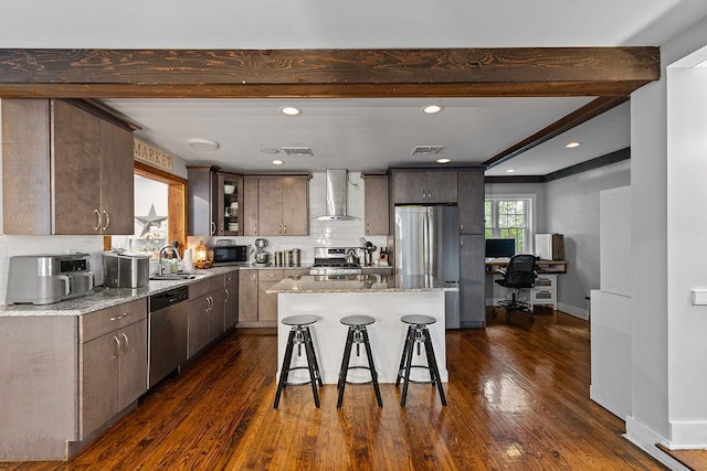 41 River Rd, Nyack, NY 10960 - kitchen with appliances with stainless steel finishes, wall chimney range hood, beamed ceiling, a kitchen breakfast bar, and light stone countertops
