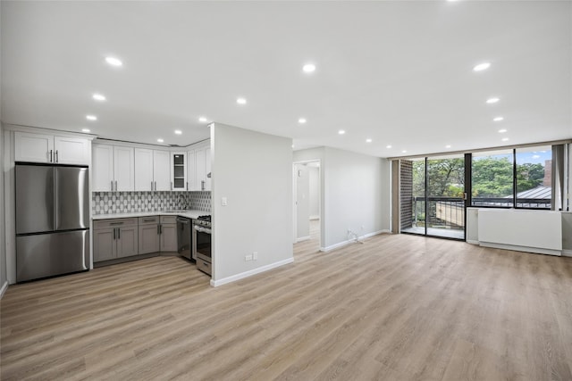 2 Bay Club Dr Unit 3P, Bayside, NY 11360 - kitchen featuring appliances with stainless steel finishes, backsplash, recessed lighting, expansive windows, and light wood finished floors