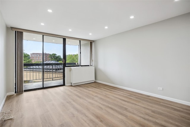 2 Bay Club Dr Unit 3P, Bayside, NY 11360 - spare room with wood finished floors, recessed lighting, and a wall of windows
