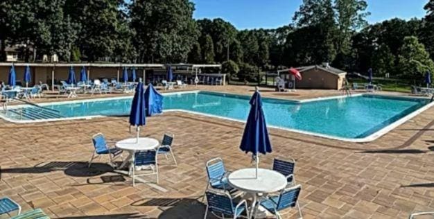 137 Eastbourne Ct Unit A, Ridge, NY 11961 - community pool featuring a patio area and view of scattered trees
